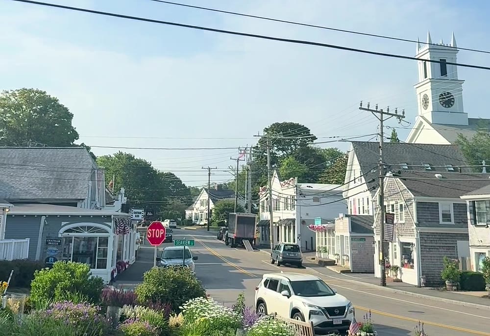Main Street in downtown Chatham, Massachusetts — the white church steeple, shingled shops and summer flower beds